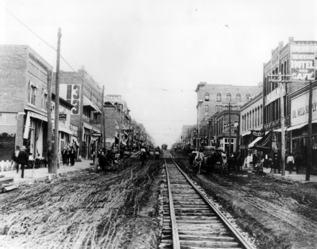 Looking south on Main from the Frisco tracks c. 1907. Trolley tracks run down middle of street. Streets aren't yet paved.