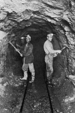 Miners trim out the Tiawah Tunnel to prepare for setting concrete forms