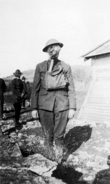 Photograph of a man in military dress and a gas mask
